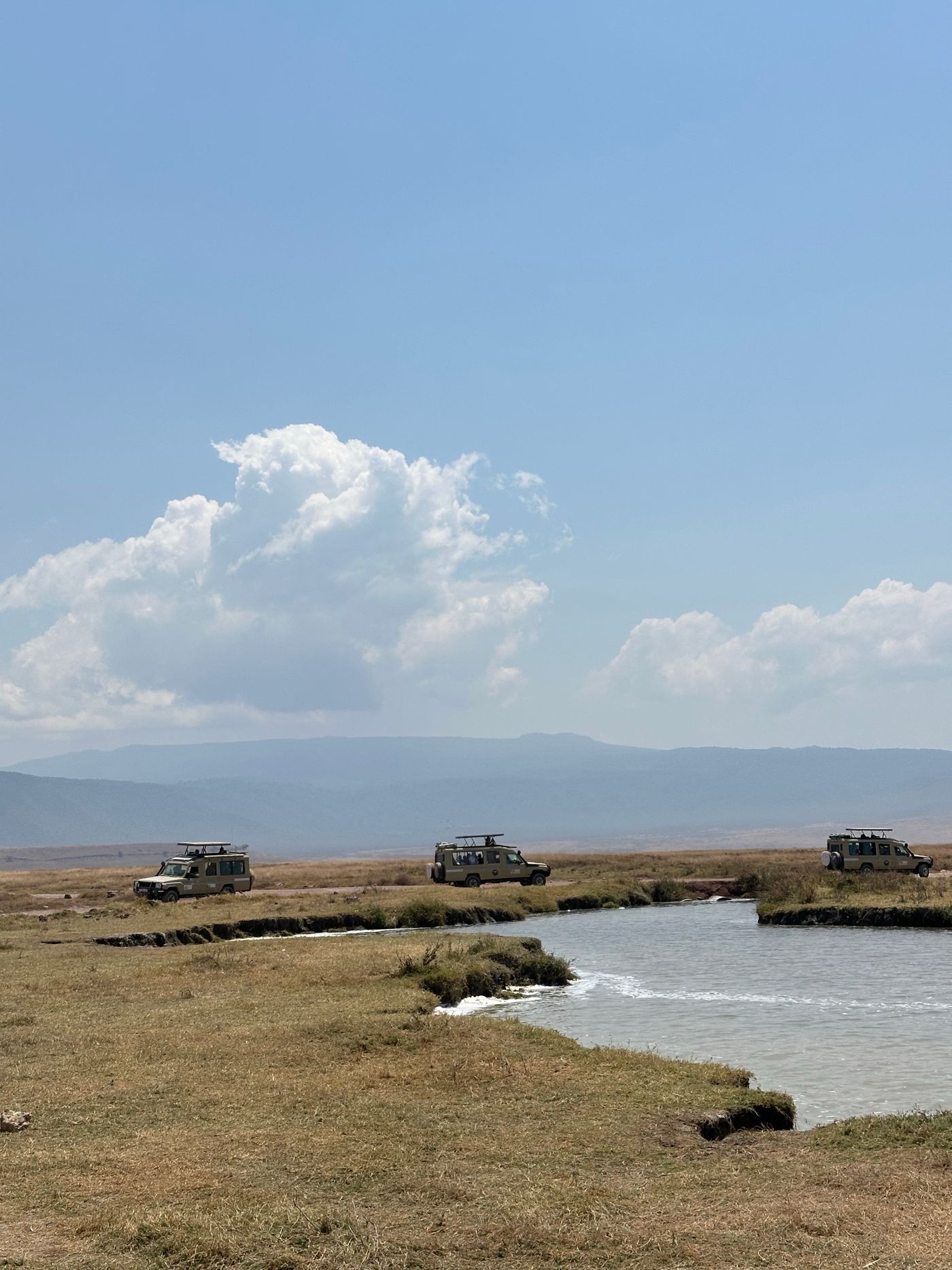 Safari vehicles on a game drive in the Ngorongoro Crater, Tanzania